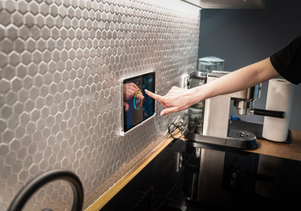 Homeowner using a wall-mounted touchscreen smart home control panel to manage a modern connected home in Bel Air, Maryland